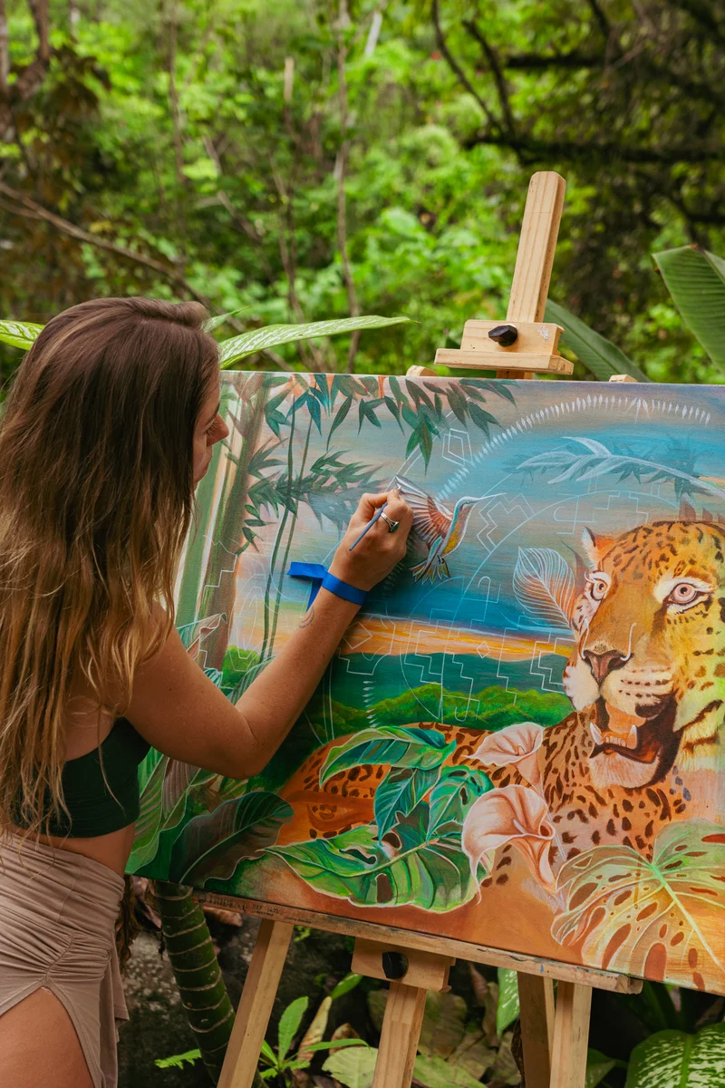 An artist painting a jaguar in the jungle