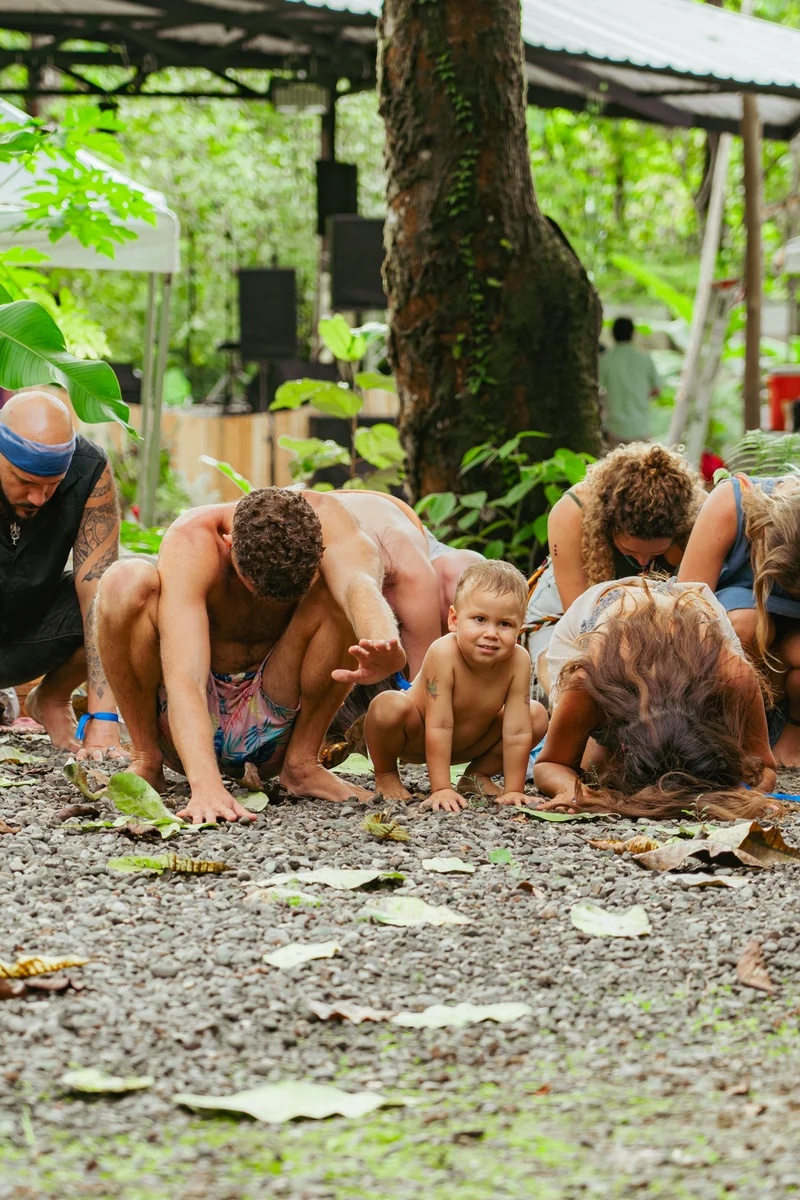 Adults and a young child playing close to the ground outdoors